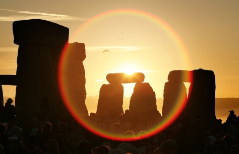 People celebrate the midsummer sun as it rises over the megalithic monument of Stonehenge on June 21, 2005 on Salisbury Plain, England. Crowds gathered at the ancient stone circle to witness the sun rise on the longest day of the year in the Northern Hemisphere.